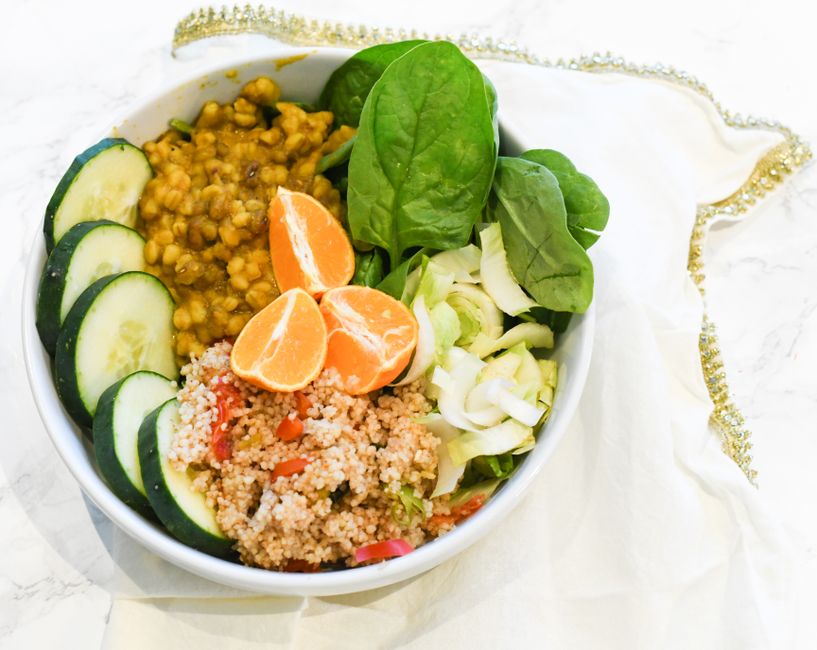 Healthy buddha bowl featuring fresh vegetables, grains, and fruit in vibrant colors.